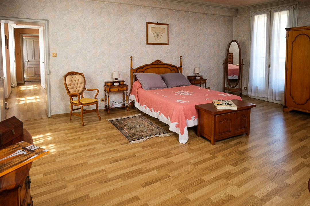 Grande chambre lumineuse avec parquet ancien dans une demeure bourgeoise à La Roche-Vineuse.