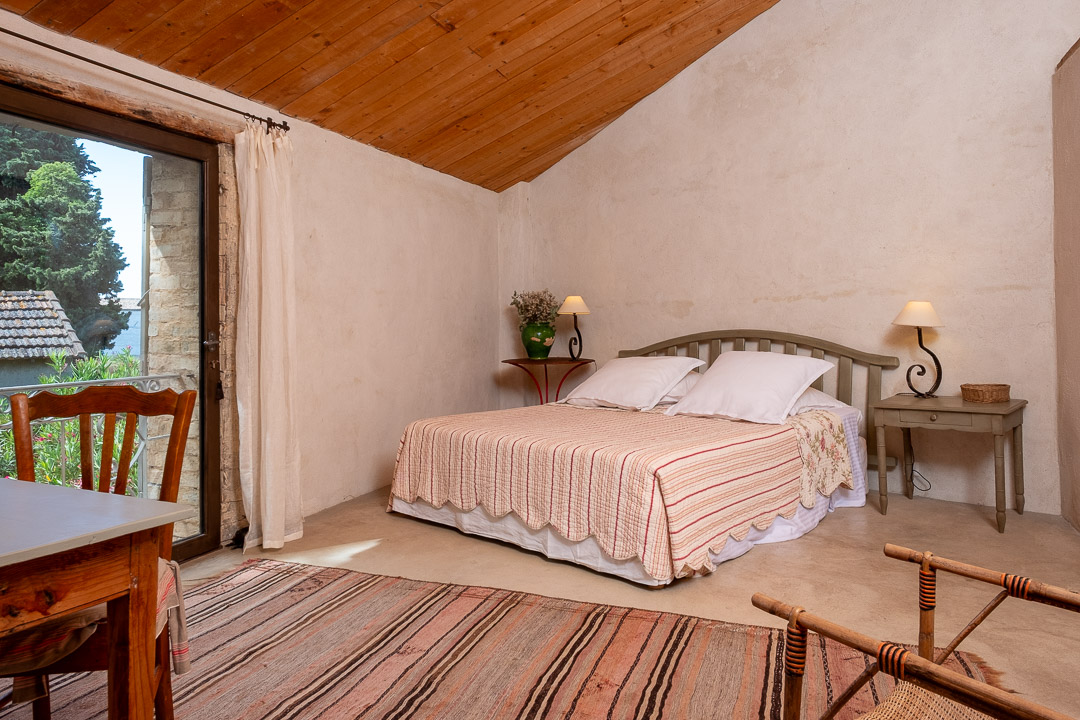 Chambre lumineuse avec porte-fenêtre ouvrant sur le jardin dans un mas provençal de caractère près de L'Isle-sur-la-Sorgue.