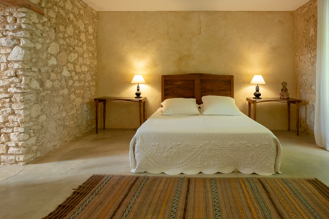 Chambre avec murs en pierre apparente dans un mas provençal près de L'Isle-sur-la-Sorgue.