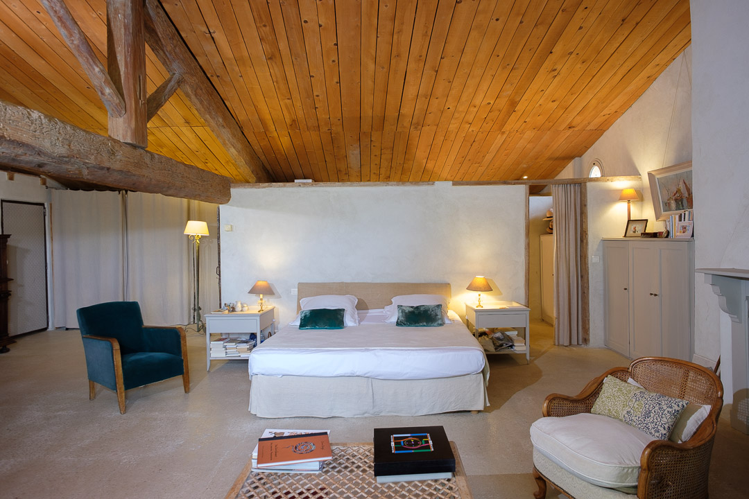 Grande suite parentale avec charpente apparente dans un mas provençal.