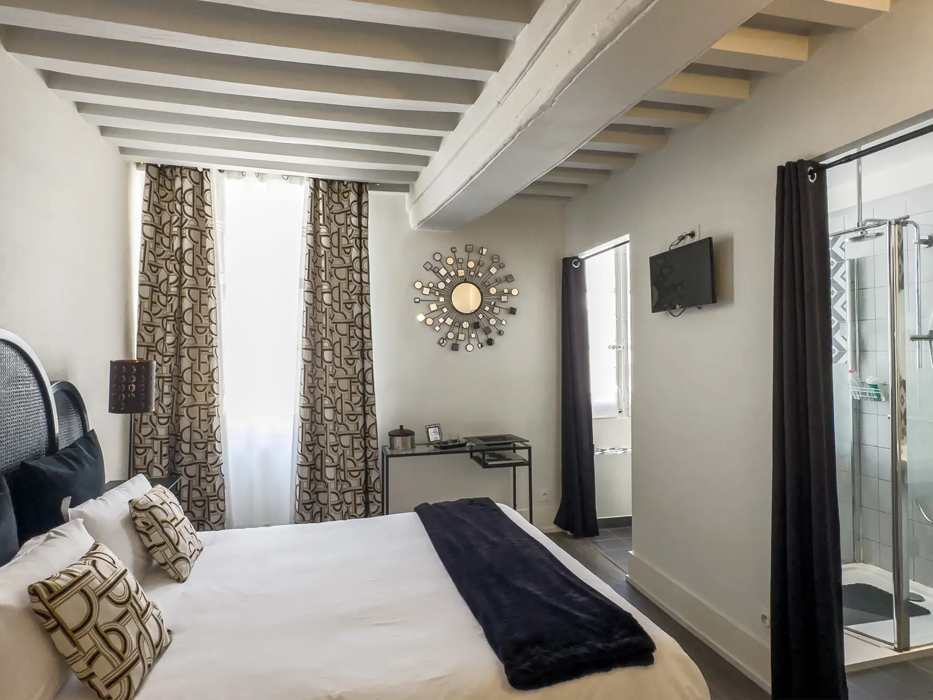 Salon d’une maison de caractère du XVIIe siècle située à Charolles en Bourgogne du Sud. La pièce présente une cheminée en pierre et un plafond à poutres apparentes typique des demeures anciennes de la région.