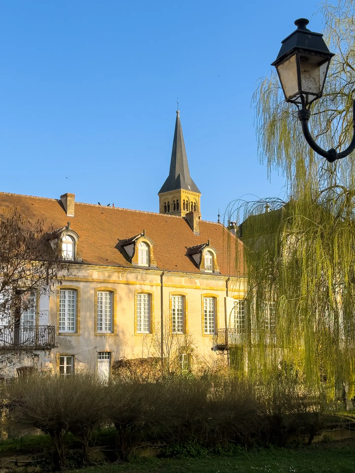 Clocher de l’église de Charolles et façade d’un bâtiment ancien au bord de l’Arconce en Bourgogne du Sud