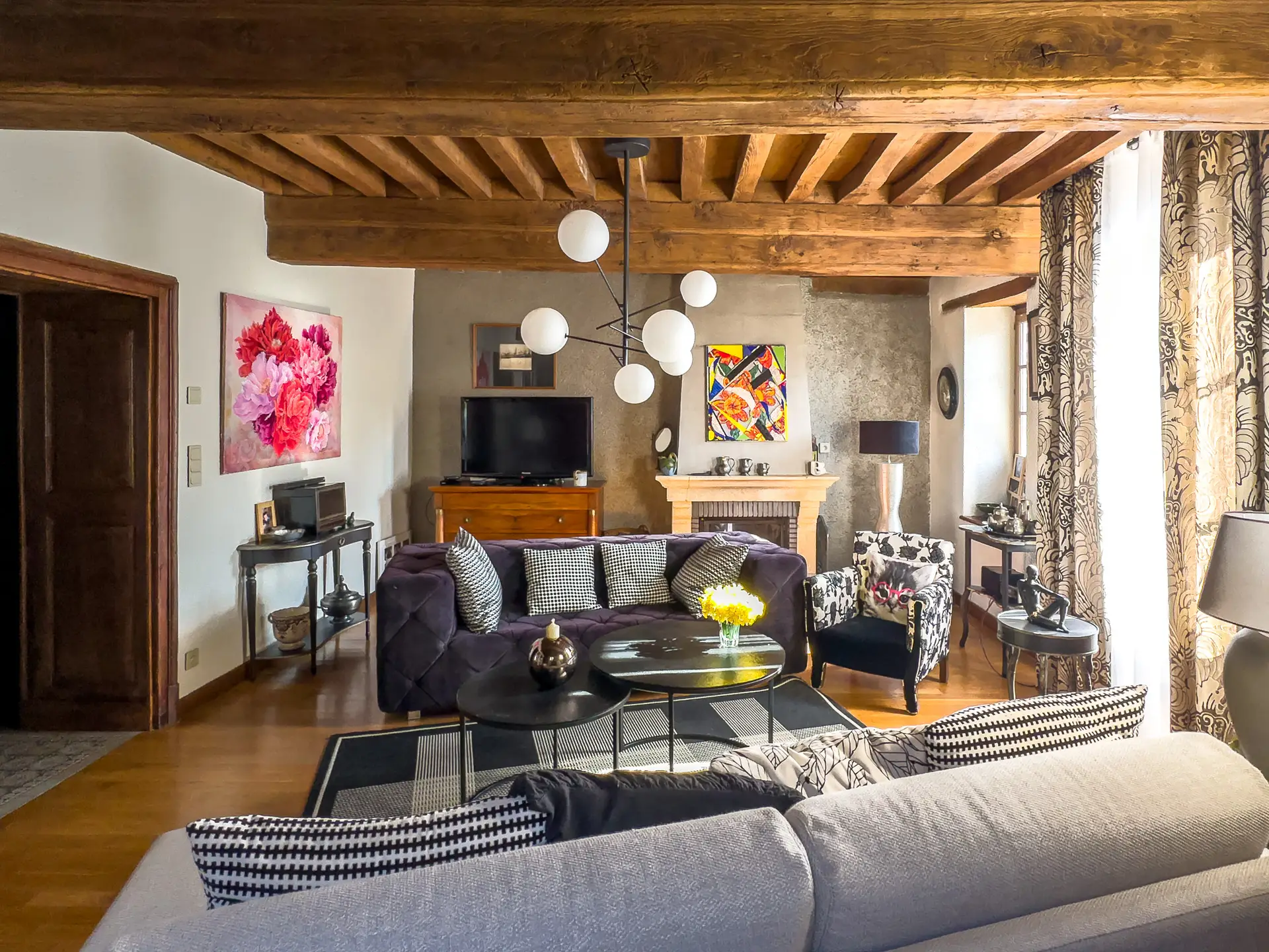 Salon avec cheminée et poutres apparentes dans une maison du XVIIe siècle à Charolles en Bourgogne du Sud