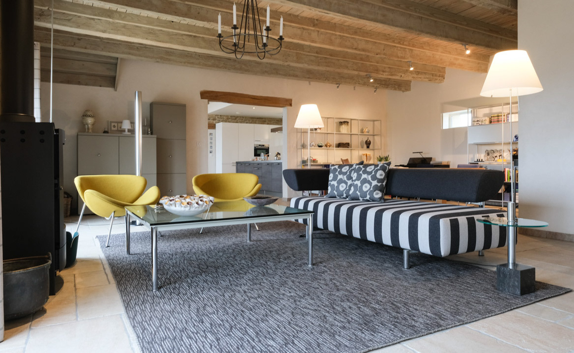 Photographie immobilière d’un salon lumineux dans une maison de caractère à Cluny