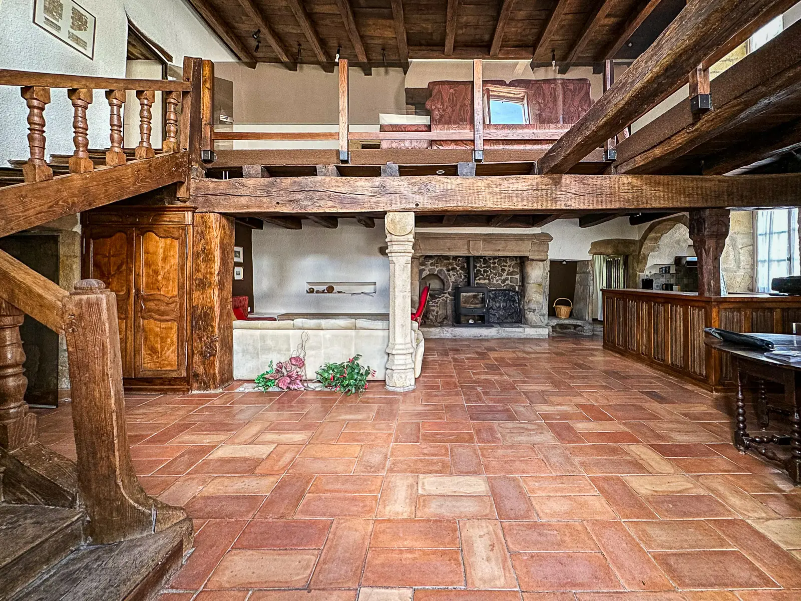 Salon avec poutres anciennes et cheminée en pierre dans une maison médiévale en Bourgogne