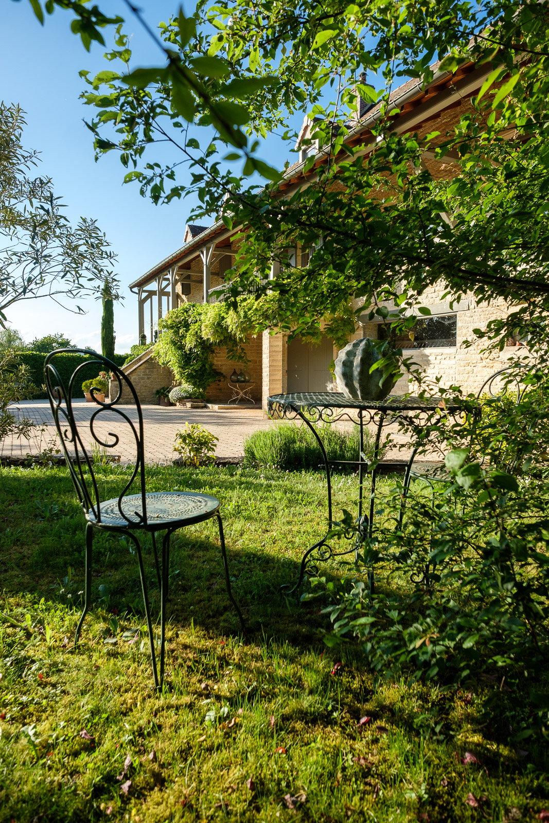 Jardin arboré avec mobilier extérieur devant une maison ancienne rénovée à Bissy-sur-Fley