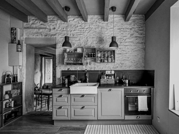 Cuisine rénovée avec poutres apparentes et murs anciens dans une maison de caractère proche de Cluny