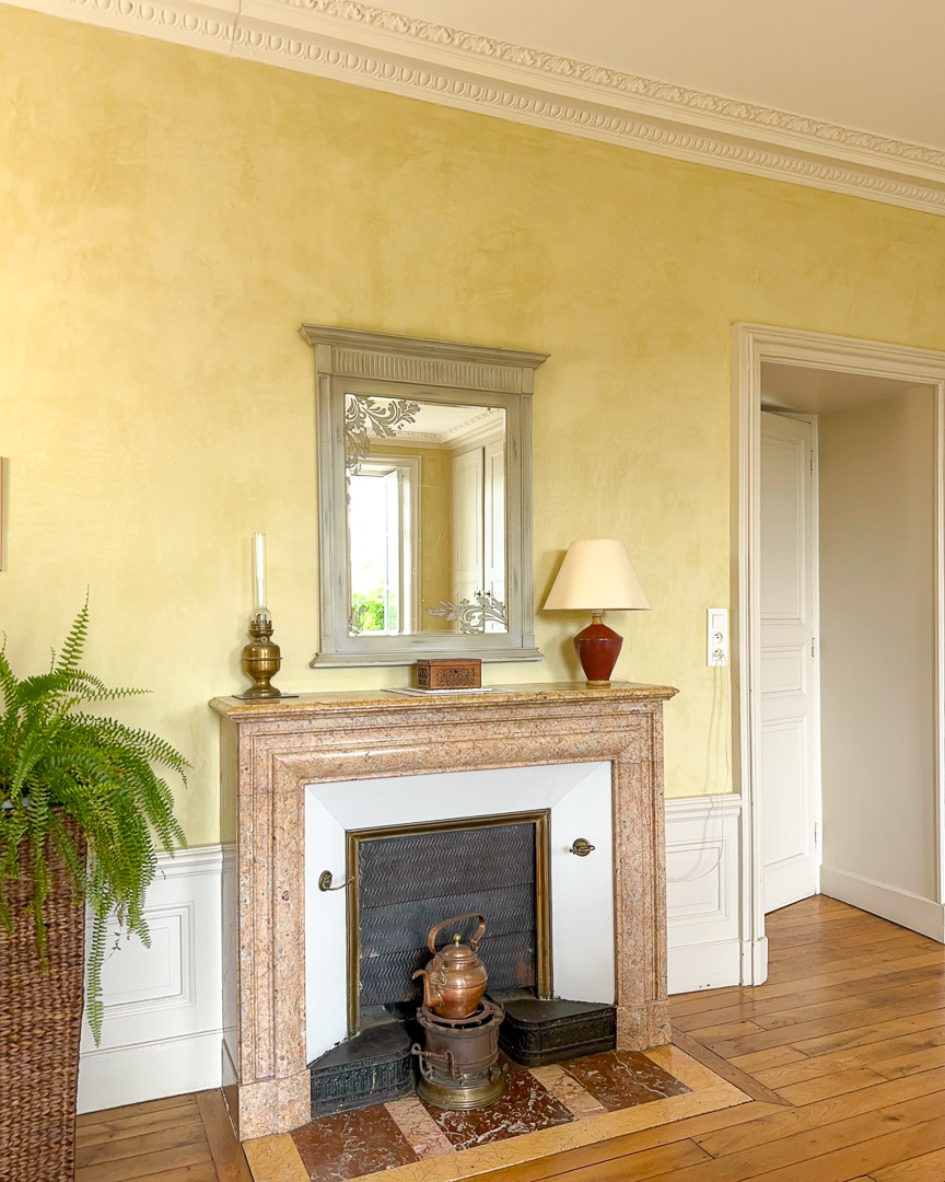 Cheminée en marbre avec miroir ancien dans une maison bourgeoise du XVIIIᵉ siècle du Clunisois.