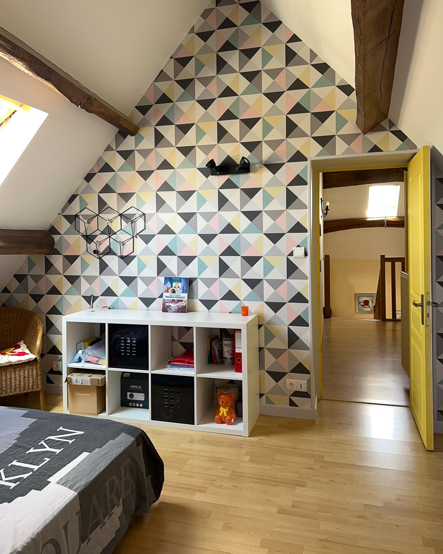 Chambre d'enfant aménagée sous les combles avec poutres apparentes dans une maison de caractère à Cortevaix, entre Cluny et Salornay-sur-Guye.