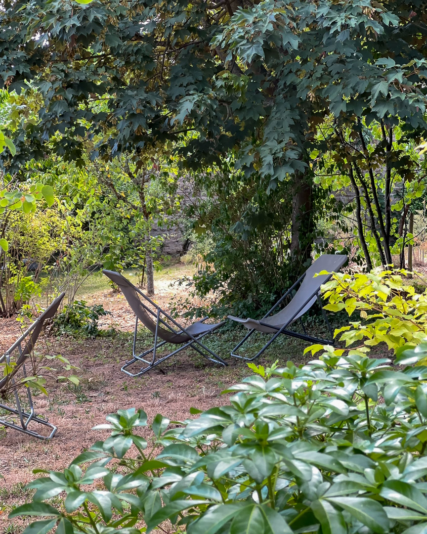 Fauteuils de détente installés sous les grands arbres du jardin d'une maison bourgeoise du XVIIIᵉ siècle en Clunisois.
