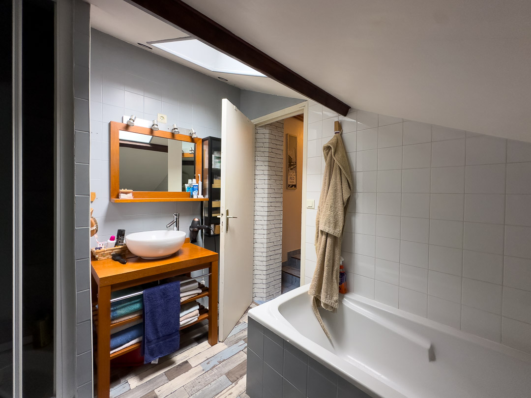 Salle de bains familiale avec baignoire, douche et meuble vasque dans une maison de caractère de 1815 à Laives.
