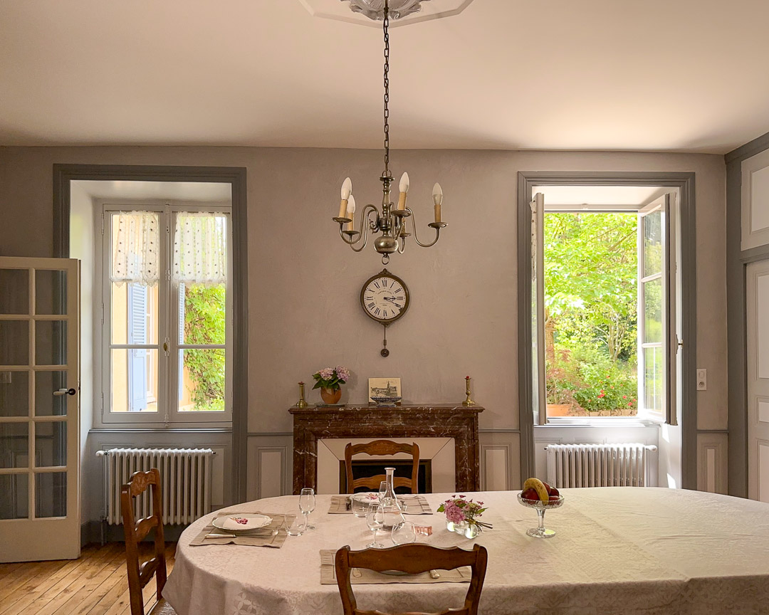 Salle à manger lumineuse avec cheminée ancienne dans une maison bourgeoise du XVIIIᵉ siècle en Bourgogne du Sud.