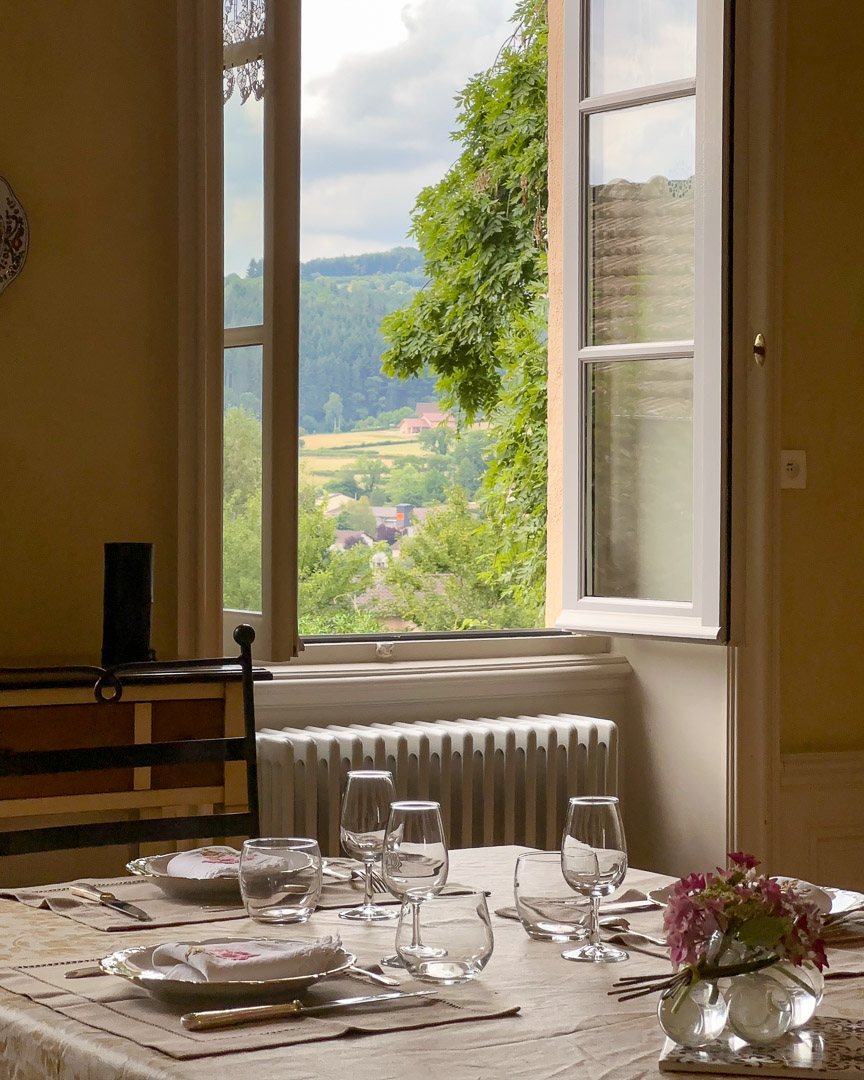 Salle à manger d'une maison bourgeoise du XVIIIᵉ siècle ouverte sur le jardin et la vallée du Clunisois.