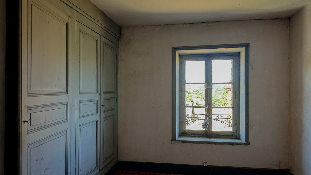 Chambre à rénover avec placards intégrés et vue sur le parc dans une demeure bourgeoise à Tramayes.
