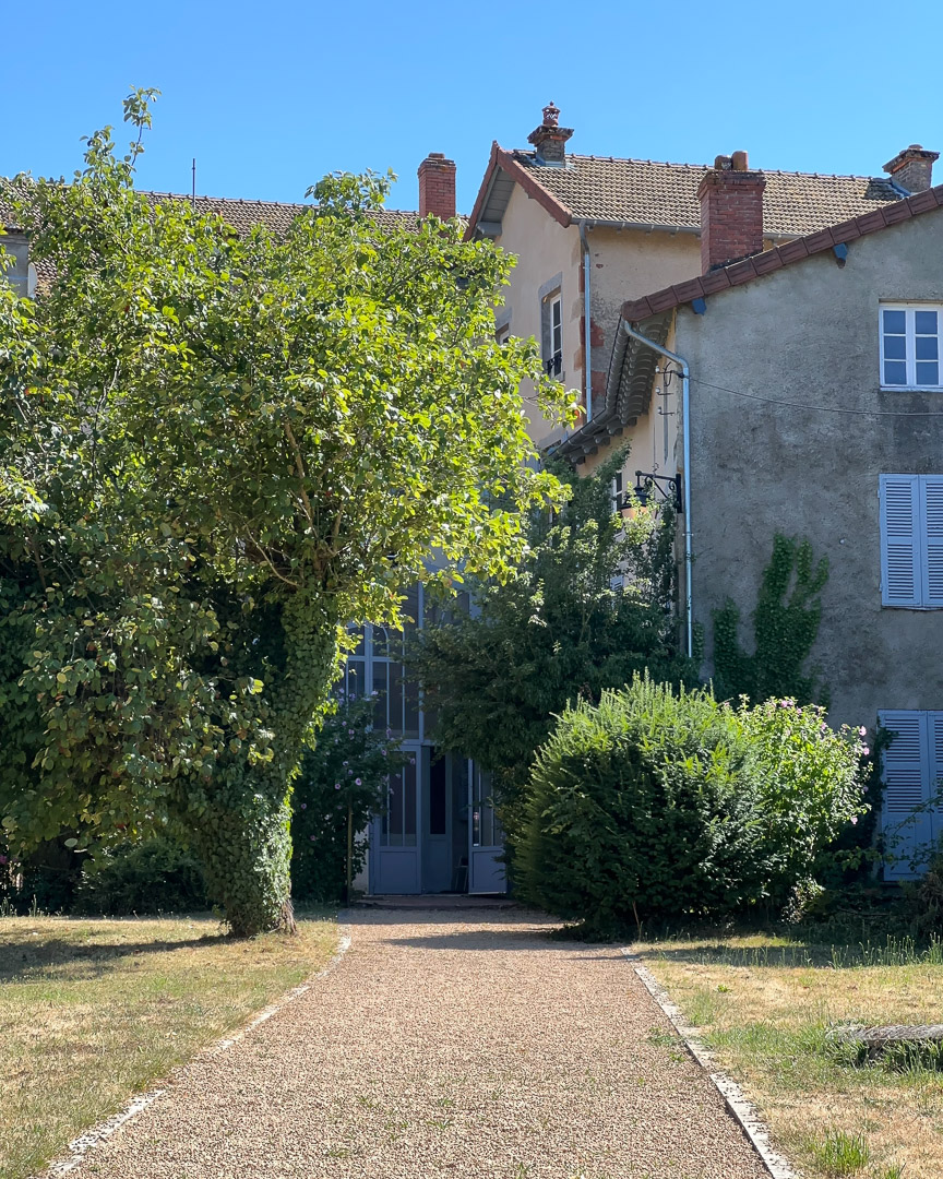 Façade arrière d'une ancienne demeure bourgeoise avec verrière et jardin clos à Tramayes.