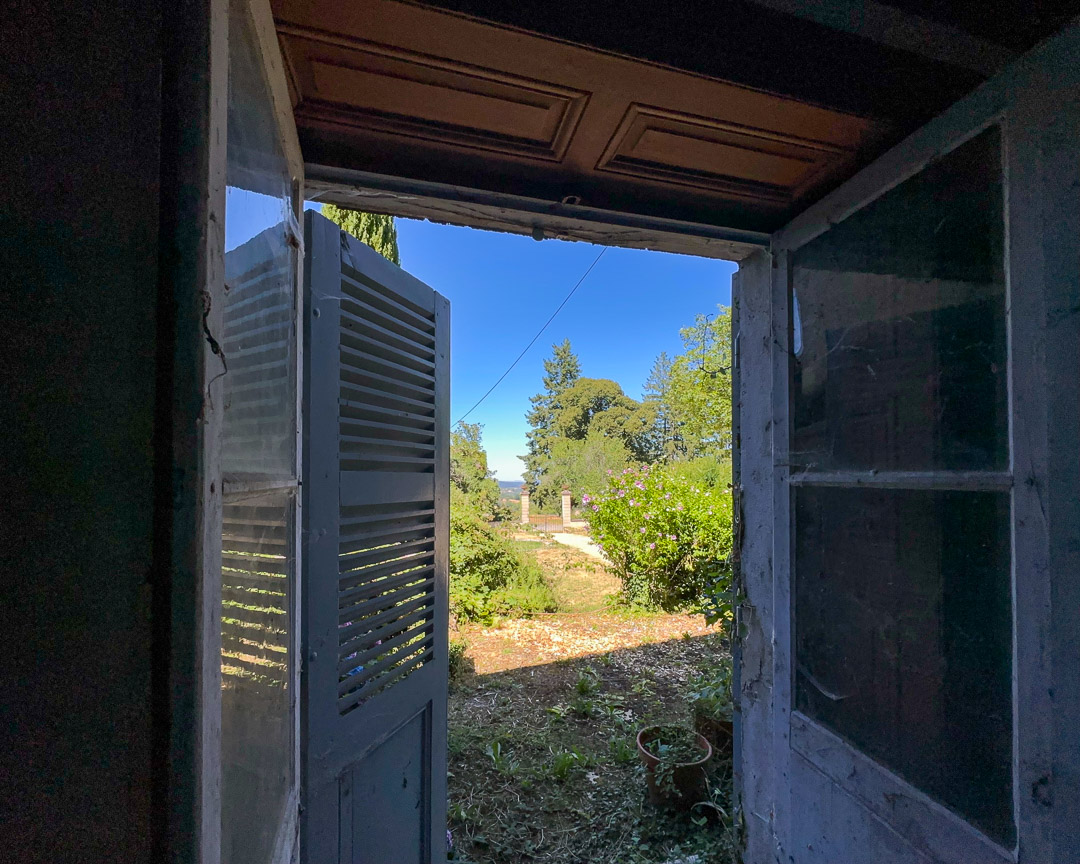 Porte ancienne ouvrant directement sur le jardin clos depuis la pièce de vie d'un appartement à rénover à Tramayes.