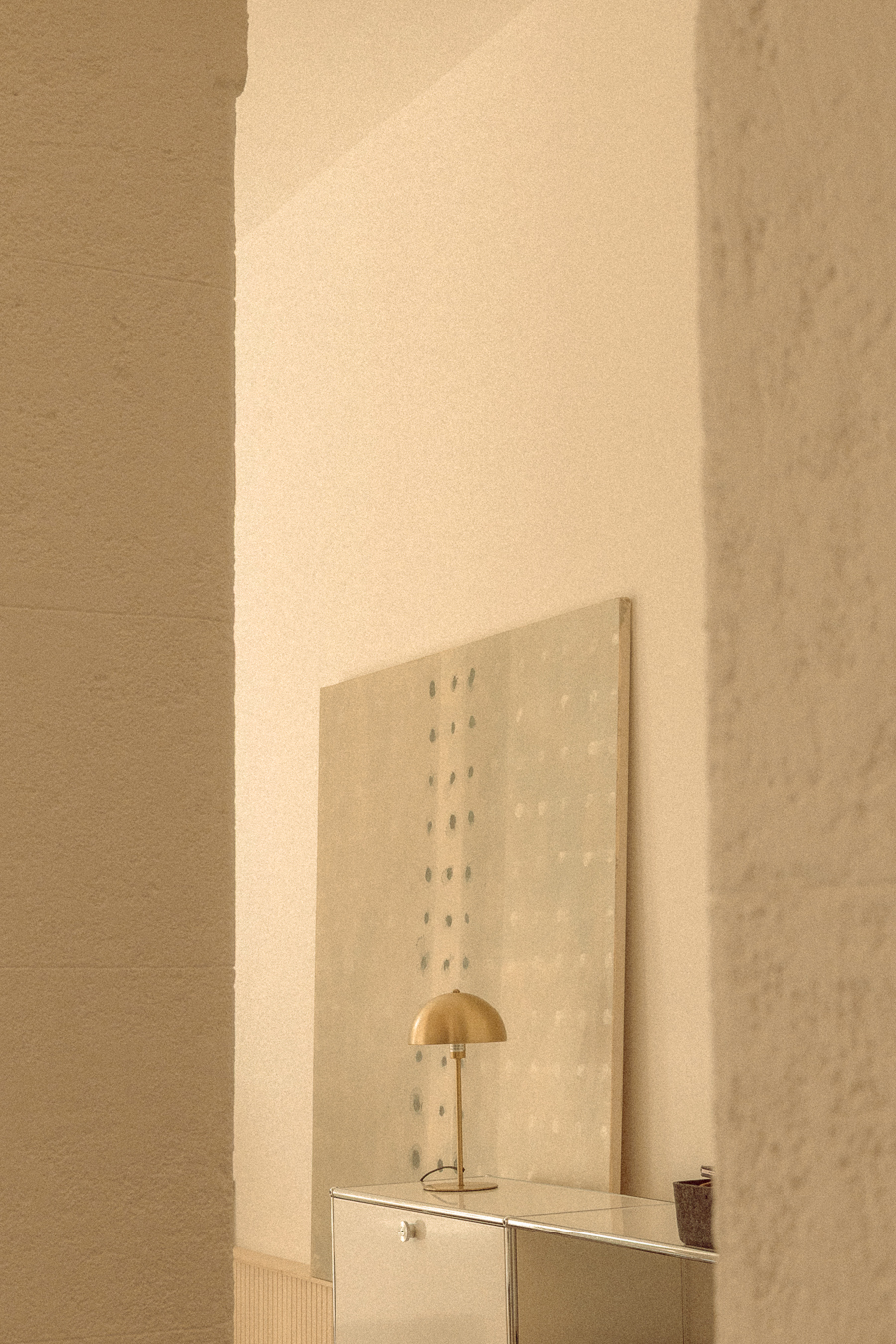 Lampe, œuvre d’art et meuble contemporains cadrés entre deux éléments architecturaux dans une ancienne chapelle à Montpellier.