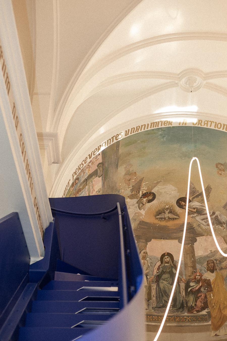 Décor peint religieux, voûtes, escalier bleu et suspension lumineuse contemporaine dans une ancienne chapelle à Montpellier.